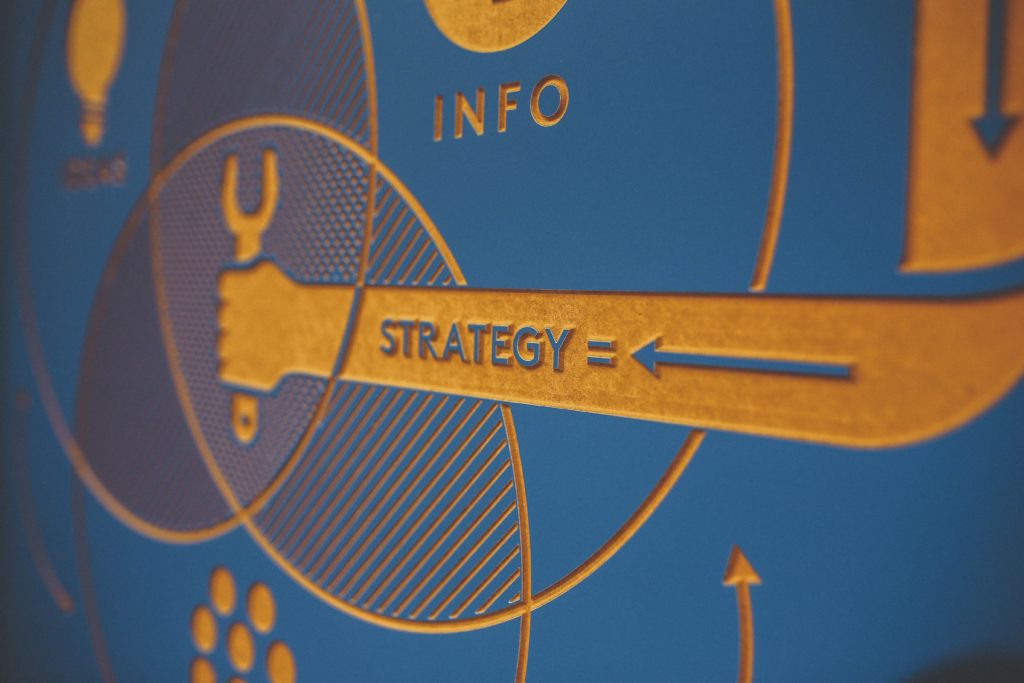 abstract image of a carving with an arrow pointing to the word strategy.