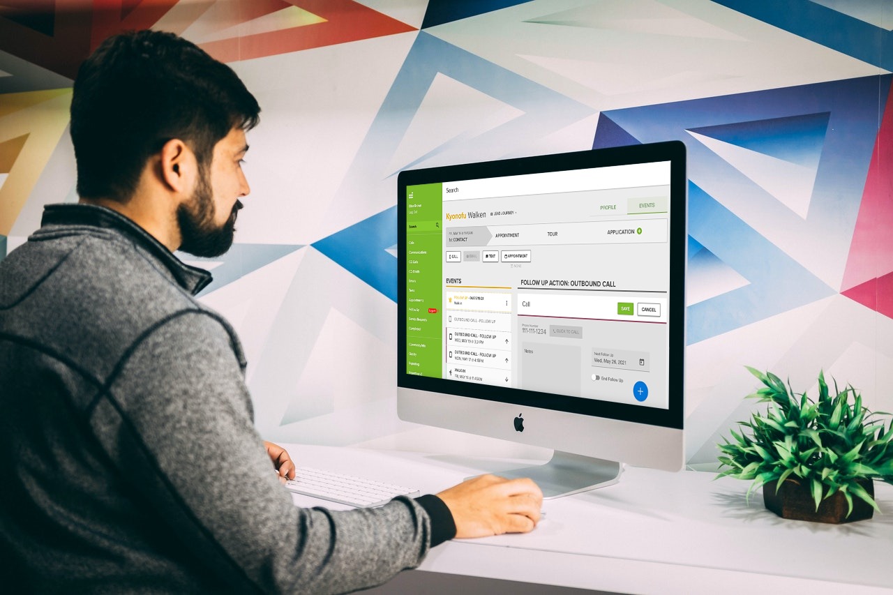 A man on a desktop computer using the Rent Dynamics CRM.